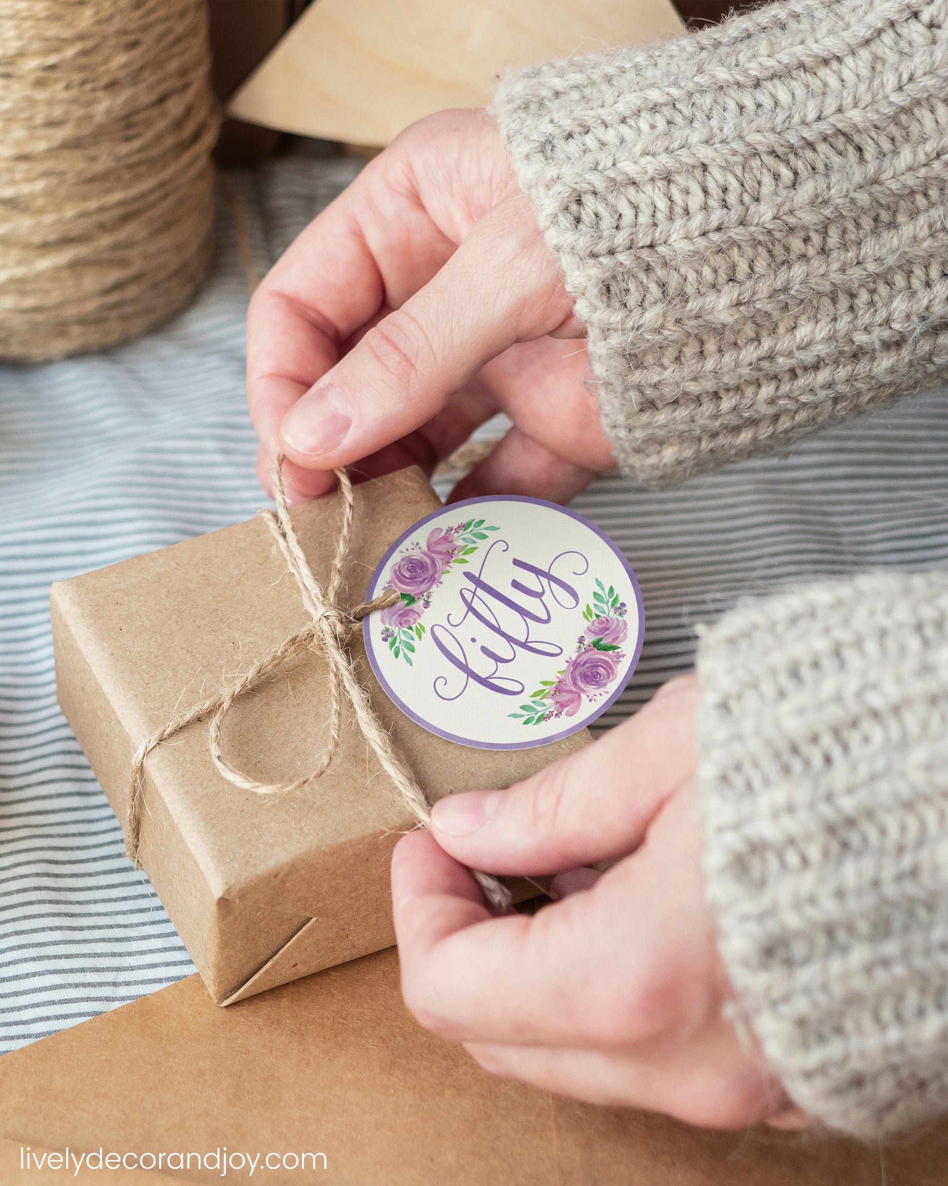 A woman wrap a simple gift with a purple watercolor printable gift tag.