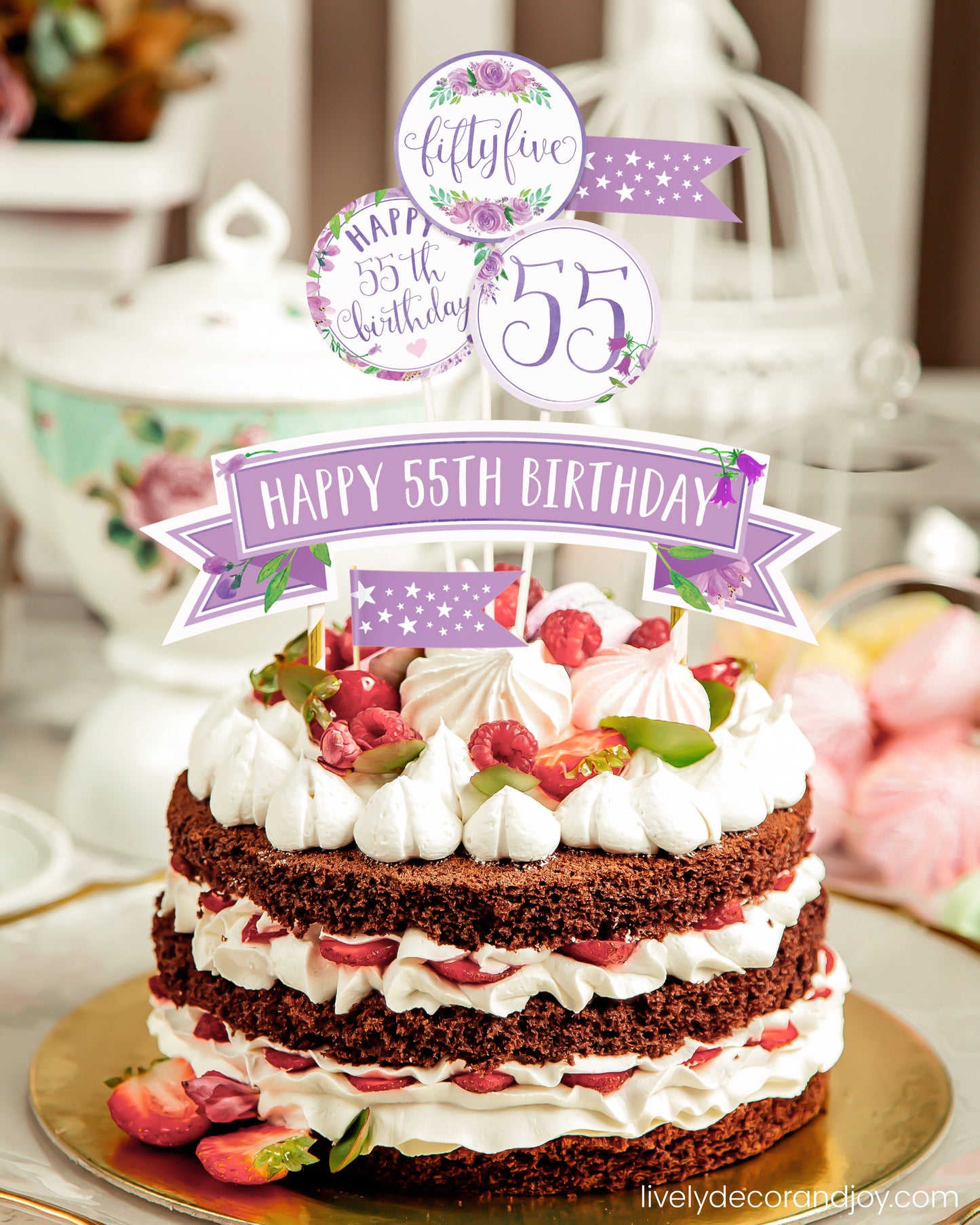 A homemade chocolate cake or strawberry cake with a unique printed cake topper made of floral watercolor designs.