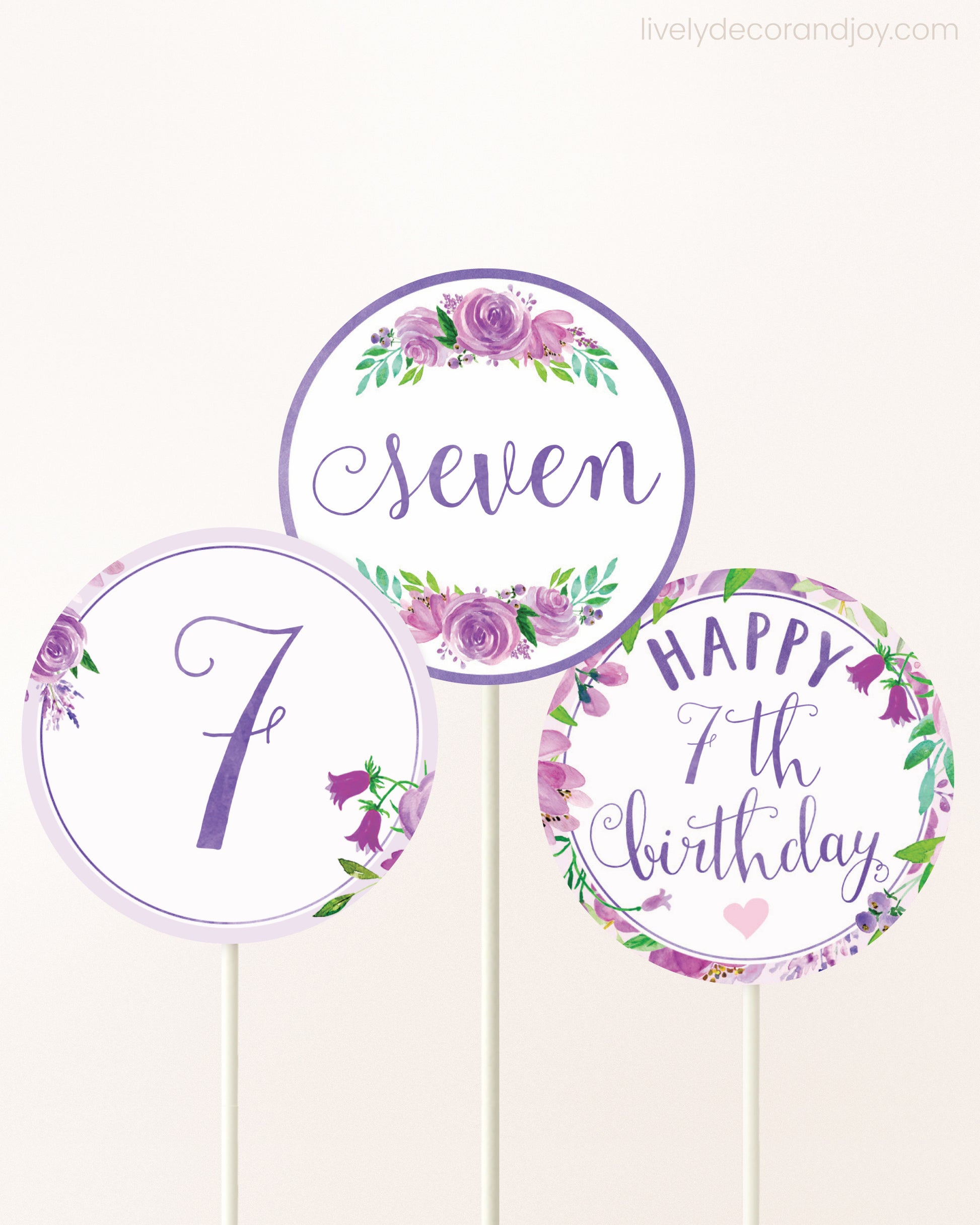 Three DIY toppers attached to lollipop sticks. They show printable cupcake topper designs with purple watercolor flowers.
