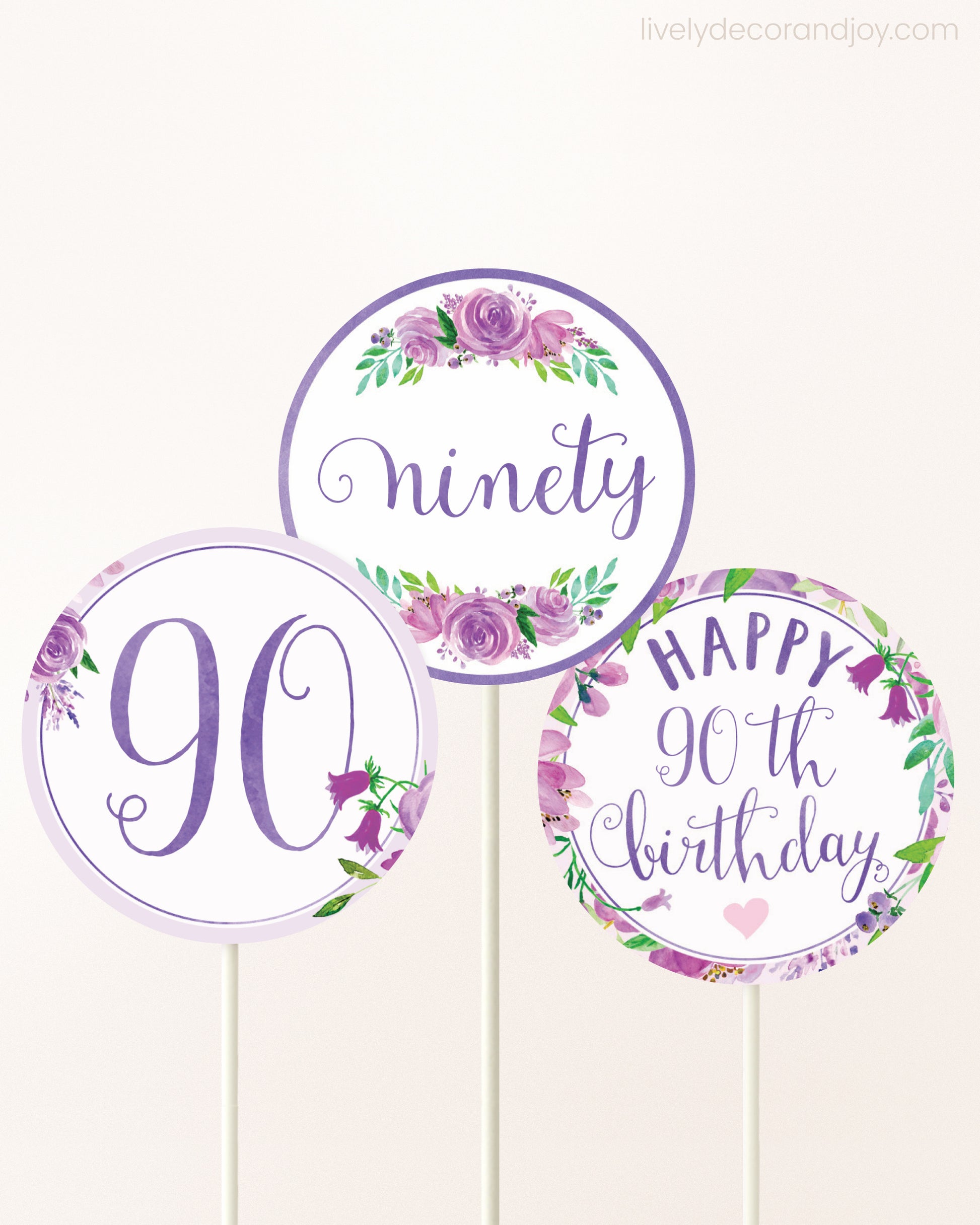Three DIY toppers attached to lollipop sticks. They show printable cupcake topper designs with purple watercolor flowers.