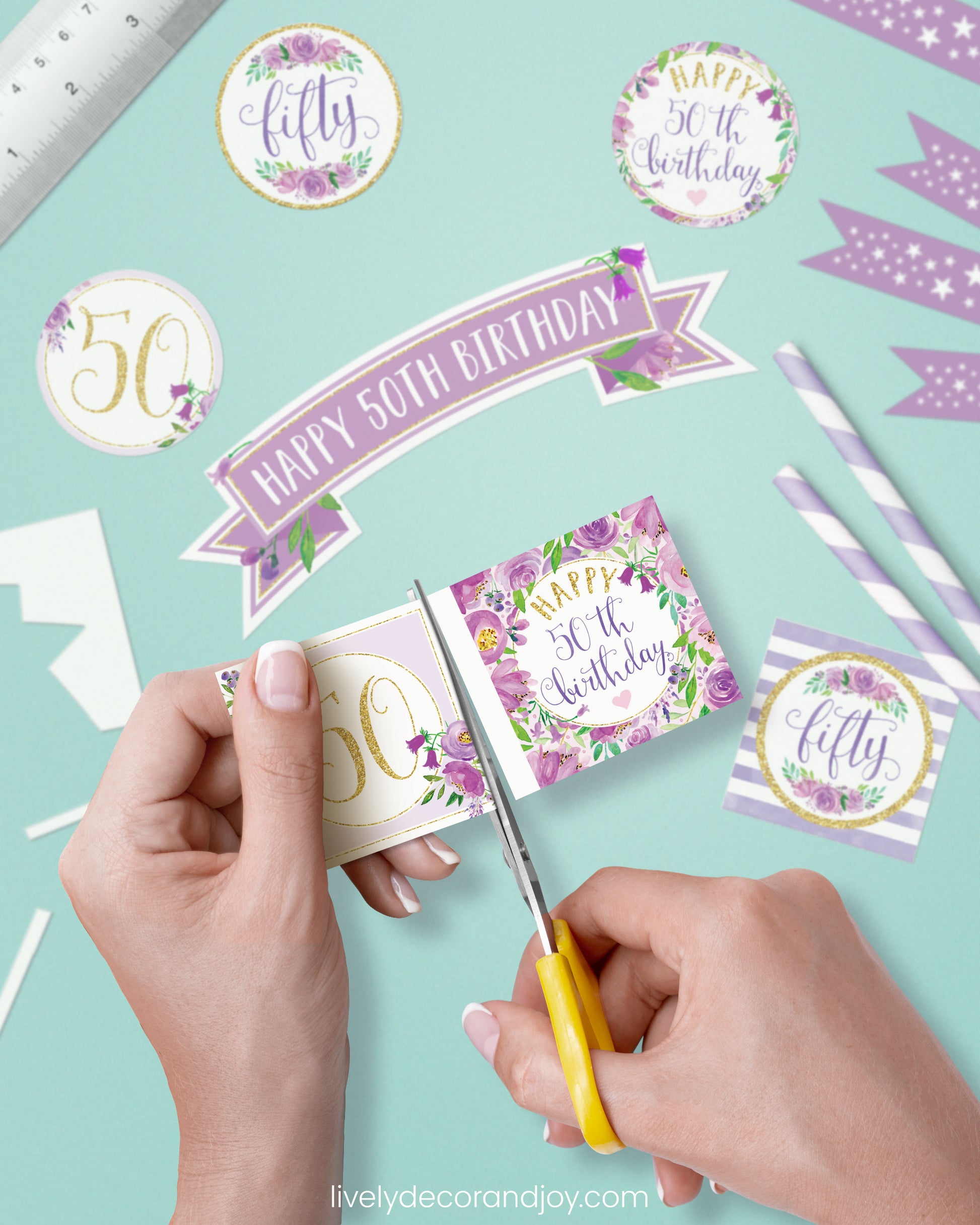 A woman cut a couple of square birthday tags after cutting round party labels, mini flags, and a cake topper.