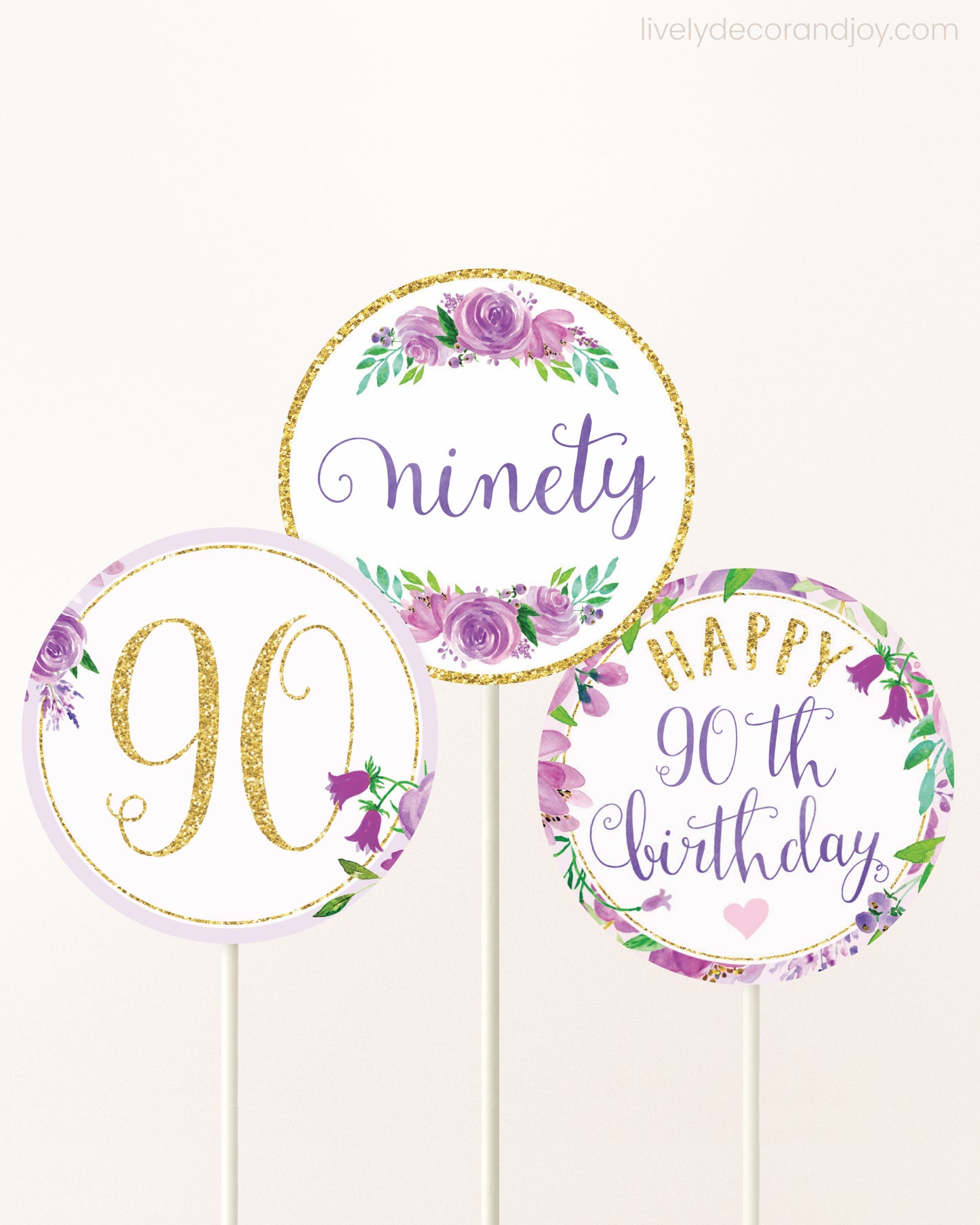Three DIY toppers attached to lollipop sticks. They show printable cupcake topper designs with purple watercolor flowers.