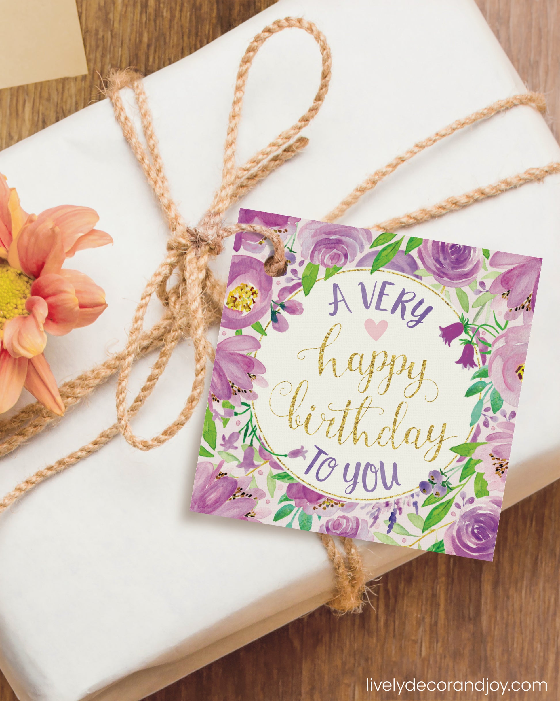 A DIY gift tag is attached to a simple birthday gift on a wooden table. Made from a printable gift tag design.