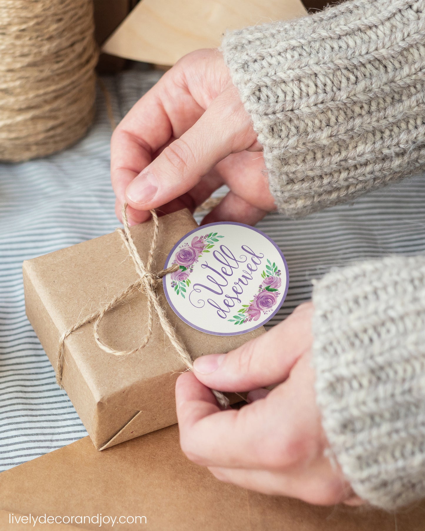 A woman wrap a Happy Retirement gift with a purple watercolor printable gift tag.