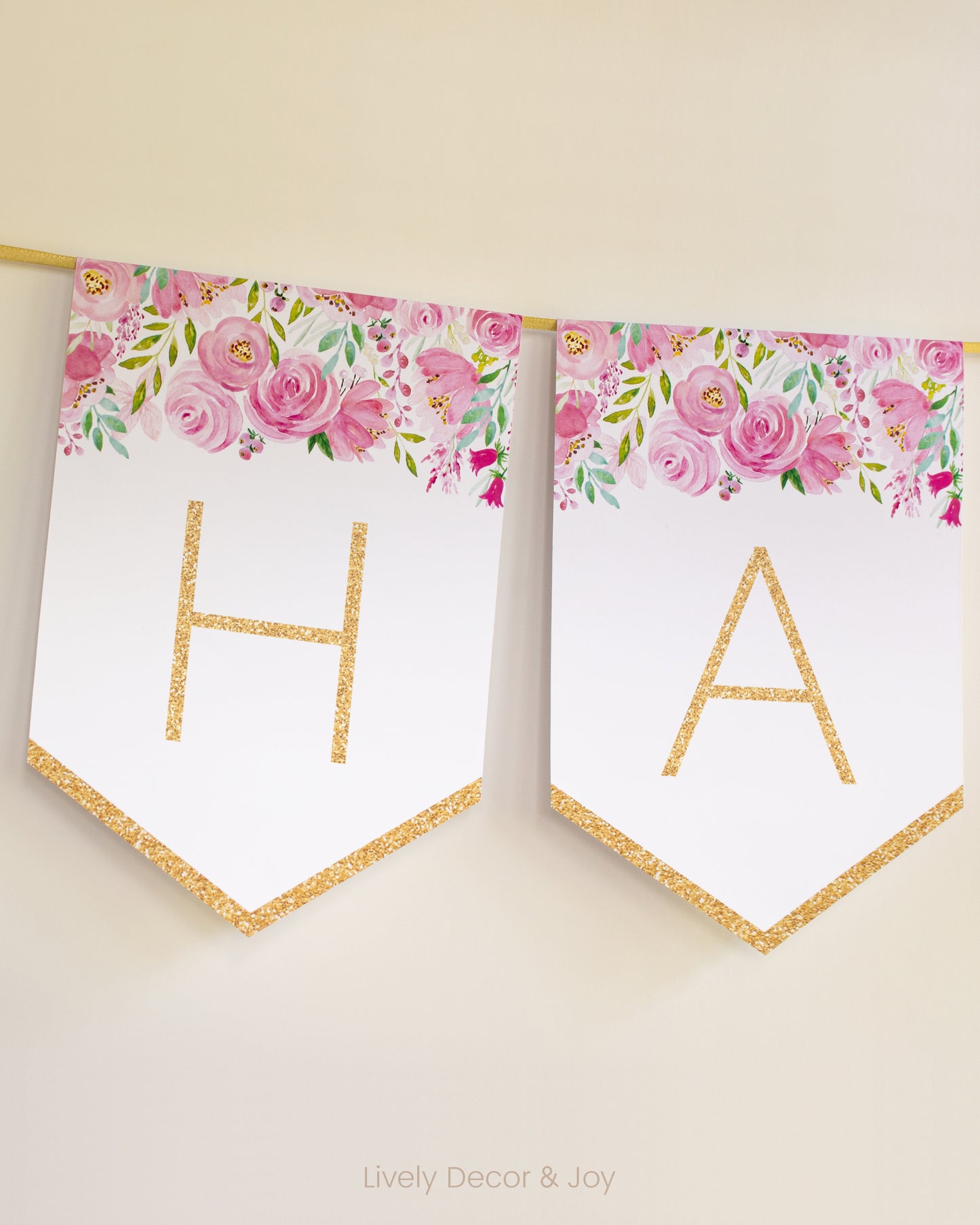 Modern banner flags on a wall with thin letters in gold: a floral Happy Retirement banner or baby shower banner.