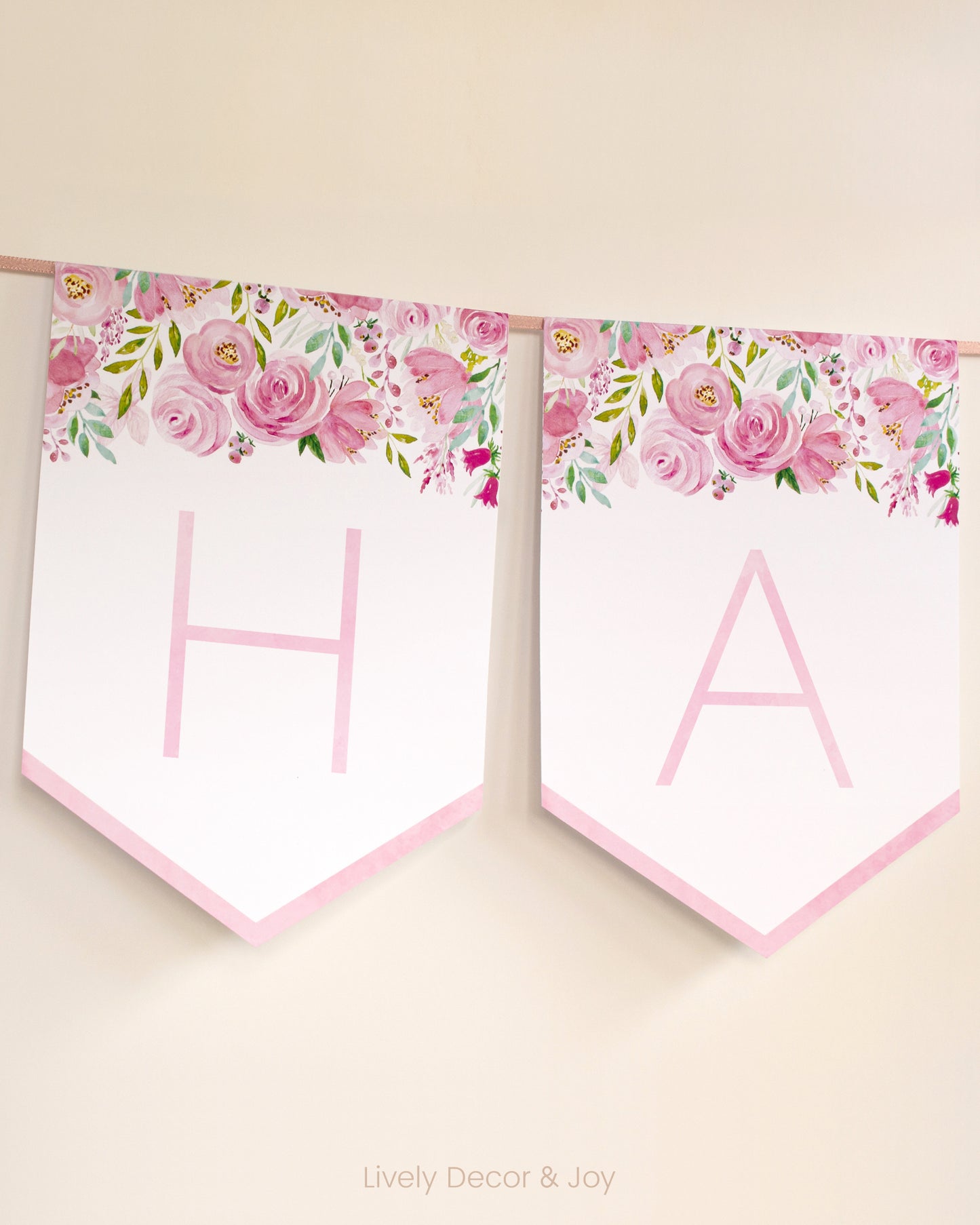 Modern banner flags on a wall with thin letters in pink: a floral Happy Retirement banner or baby shower banner.