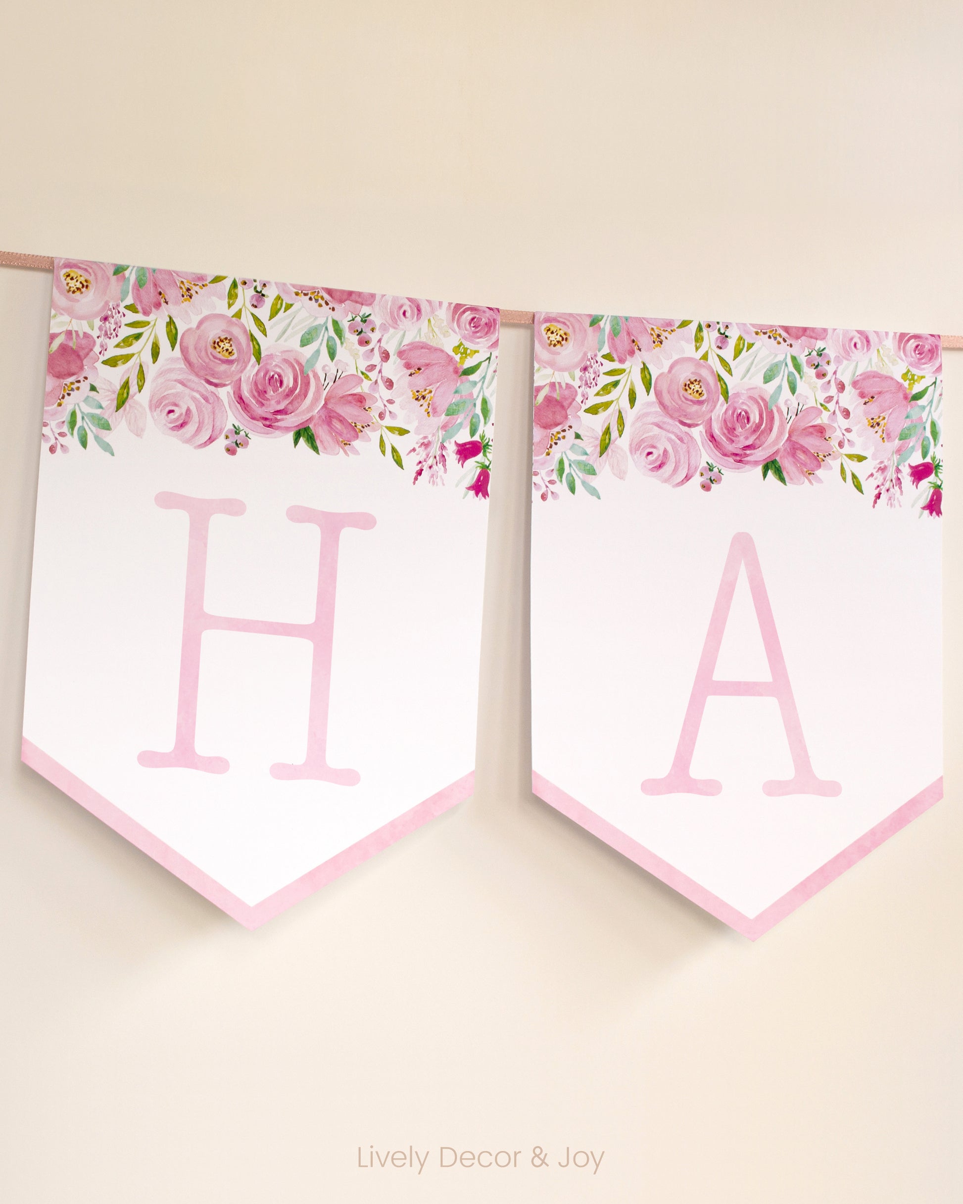 Vintage banner flags on a wall with typewriter letters in pink: a Happy Birthday banner or wedding sign with pink flowers.
