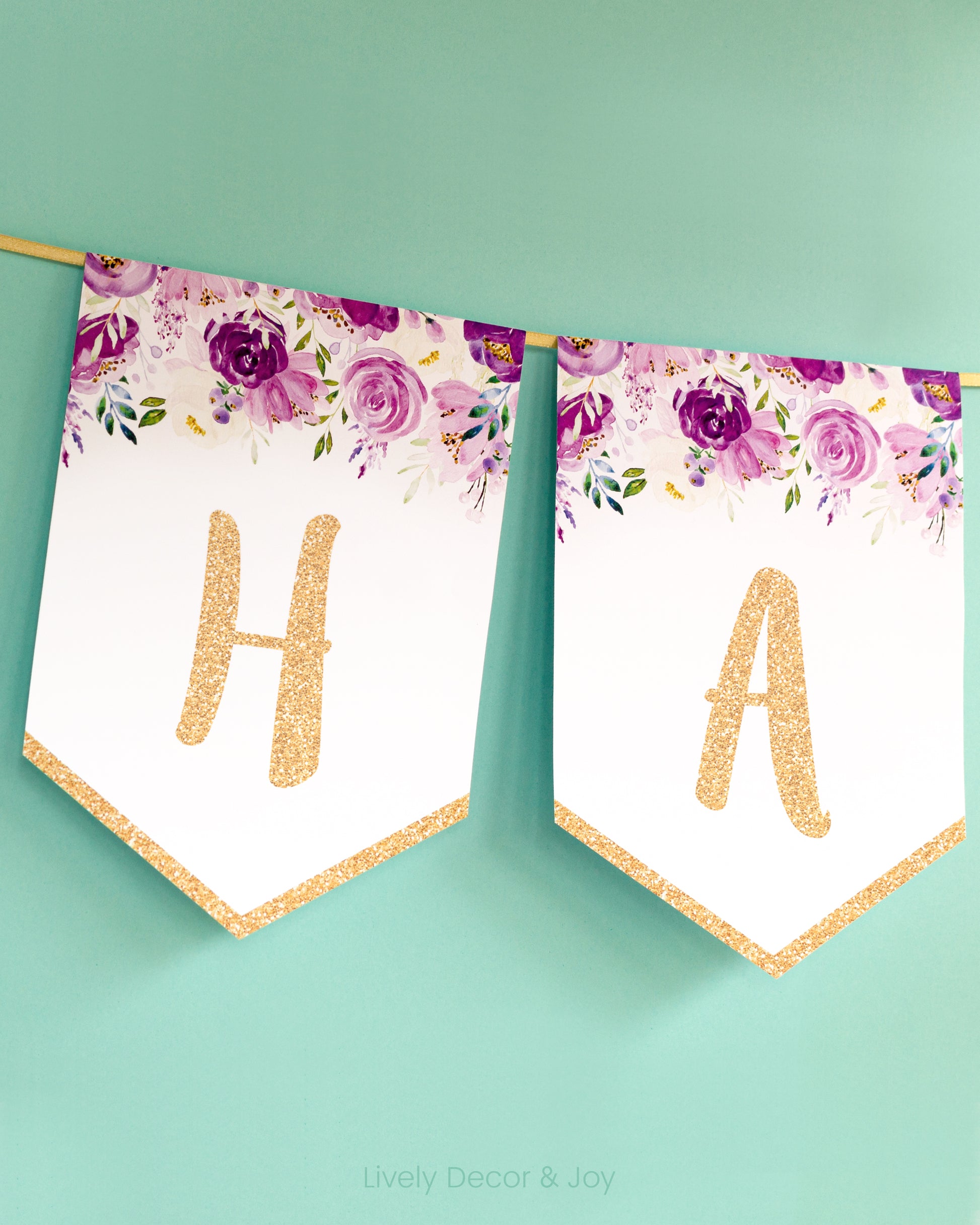 Casual banner flags on a wall with handwritten letters in gold: a floral Happy Birthday banner or engagement banner.