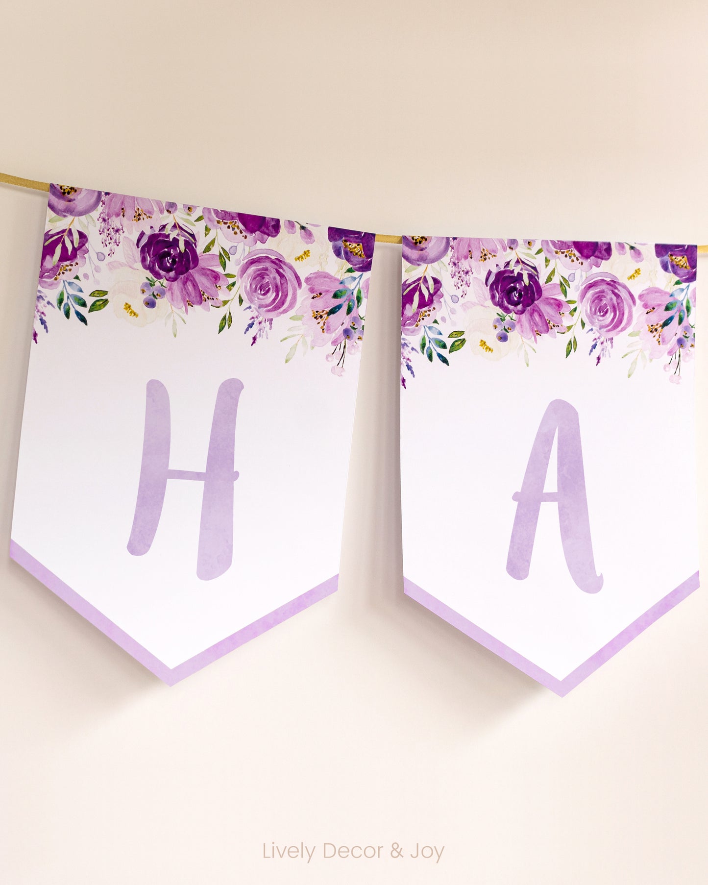 Casual banner flags on a wall with handwritten letters: a purple floral Happy Birthday banner or engagement banner.