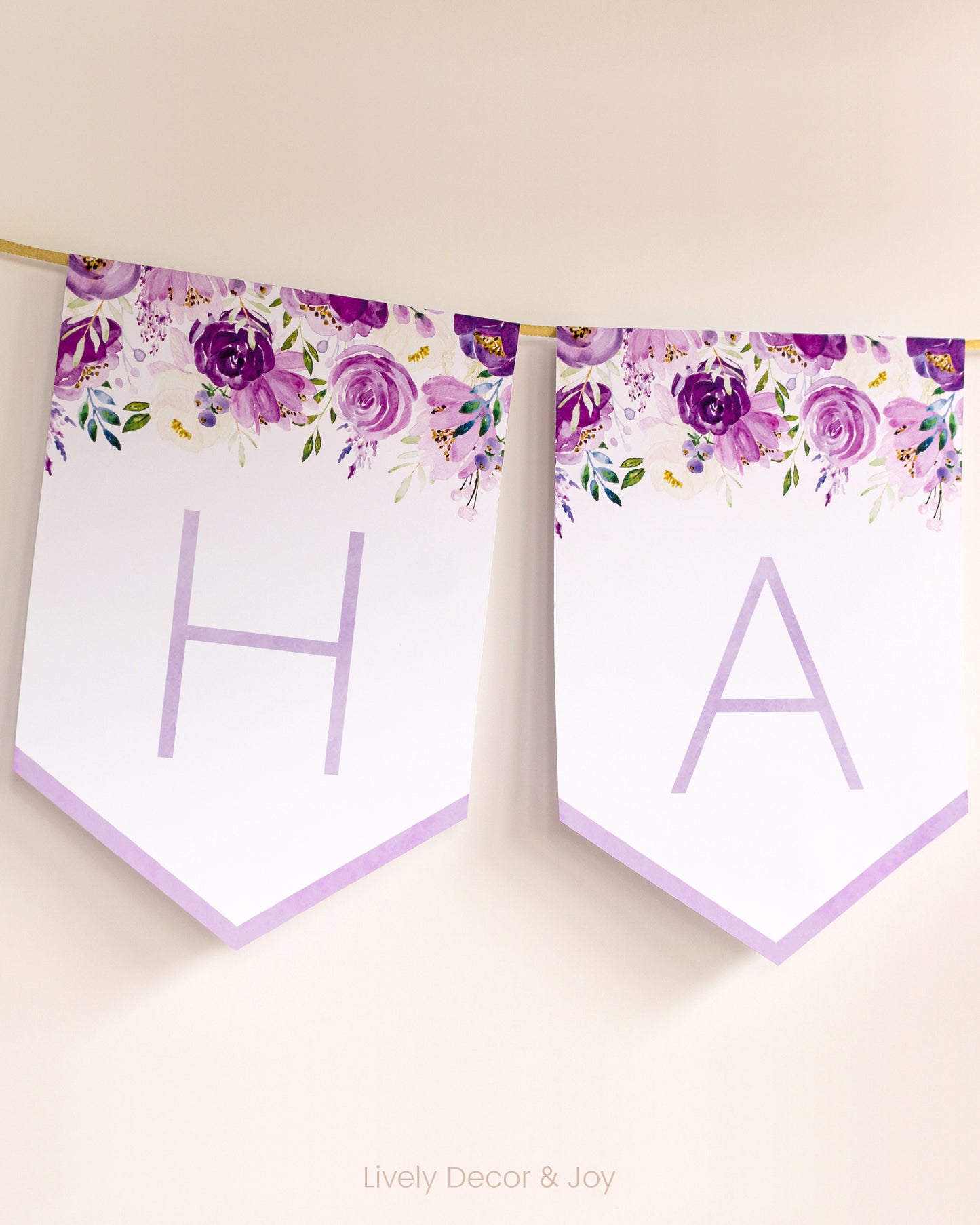 Modern banner flags on a wall with thin letters: a purple floral Happy Retirement banner or baby shower banner.