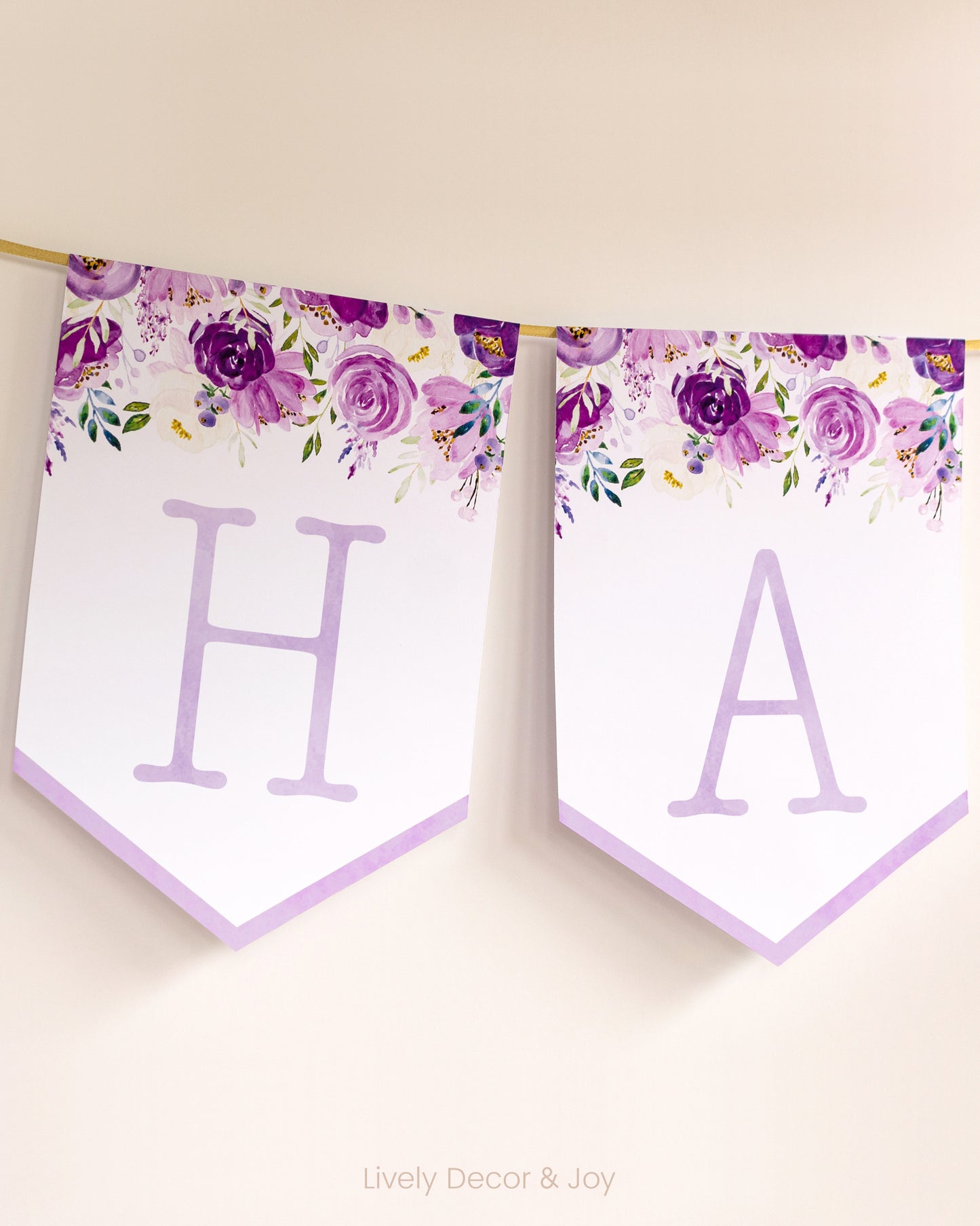 Vintage banner flags on a wall with typewriter letters: a purple Happy Birthday banner or wedding sign with purple flowers.