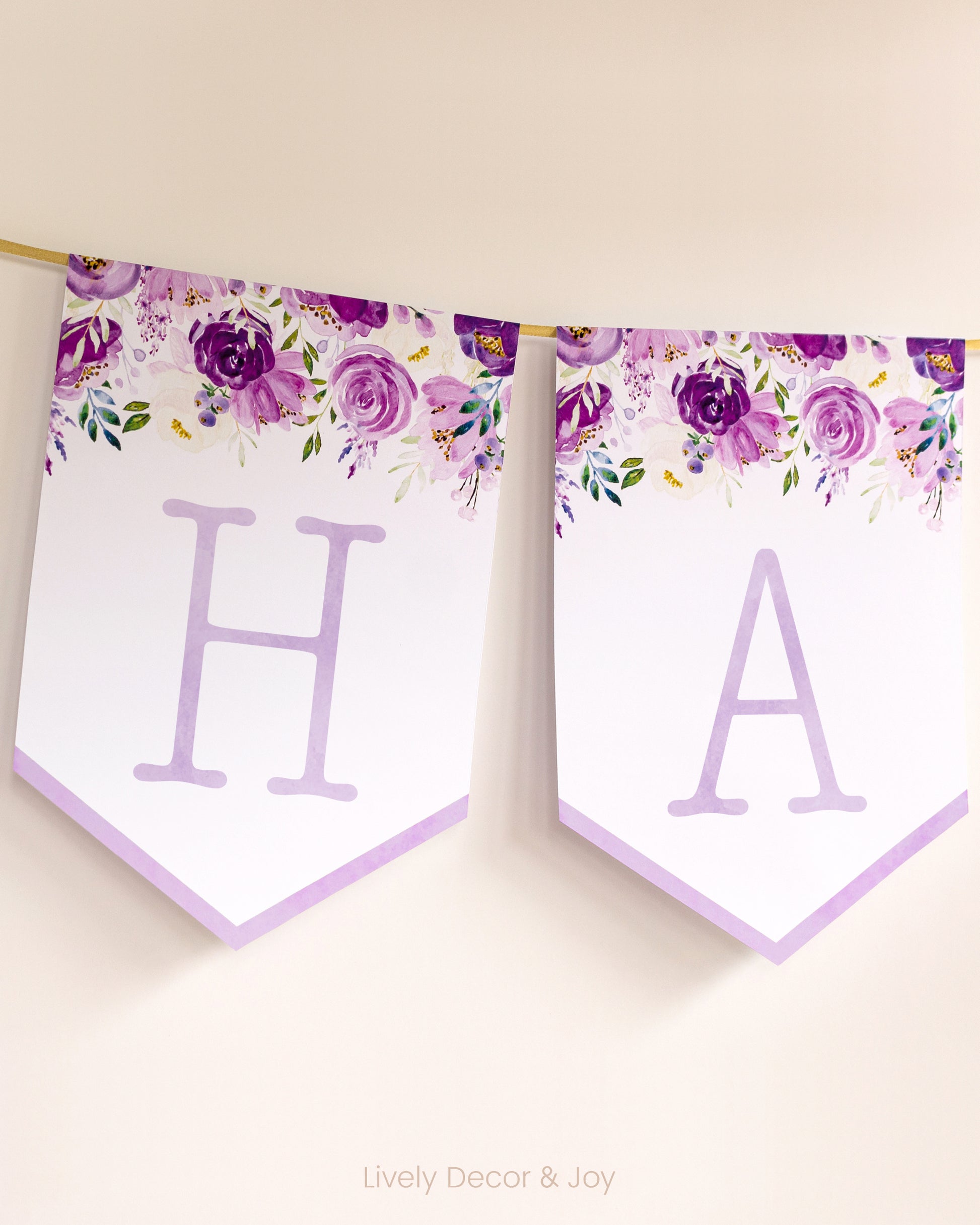 Vintage banner flags on a wall with typewriter letters: a purple Happy Birthday banner or wedding sign with purple flowers.