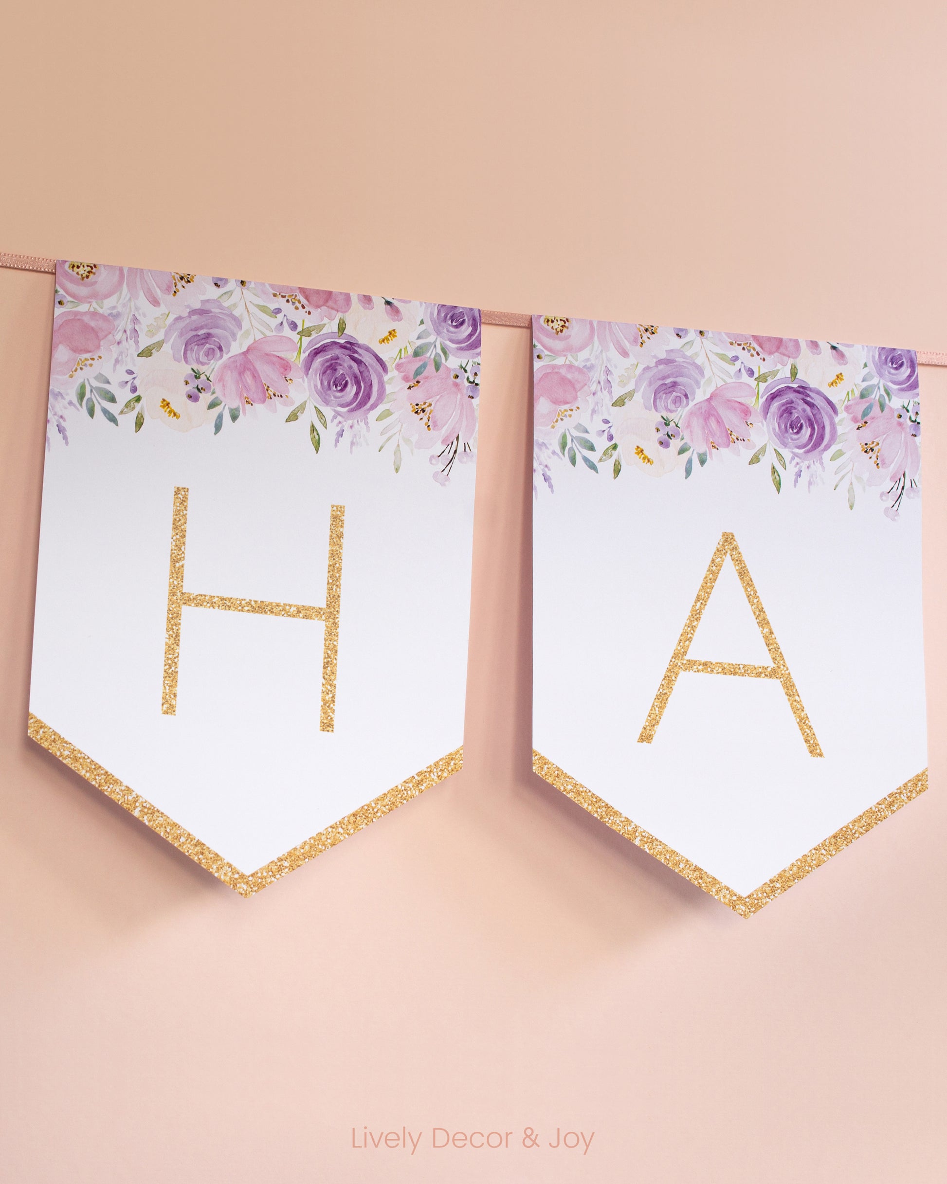 Modern banner flags on a wall with thin letters in gold: a floral Happy Retirement banner or baby shower banner.