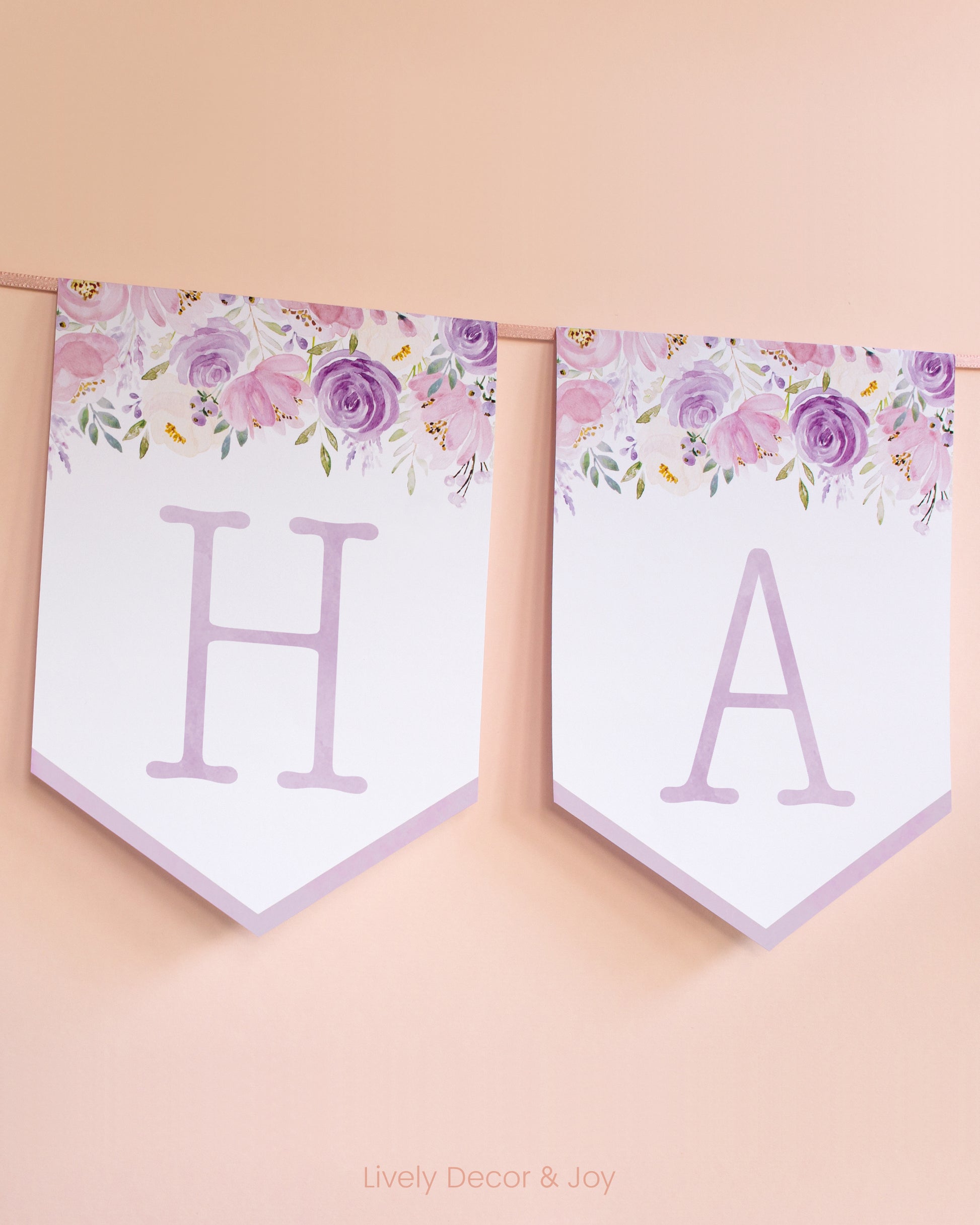 Vintage banner flags with typewriter letters in purple: a Happy Birthday banner or wedding sign with blush flowers.